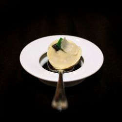 Ravioli filled with a black truffle broth and topped with Parmesan served on something called an "anti-plate."