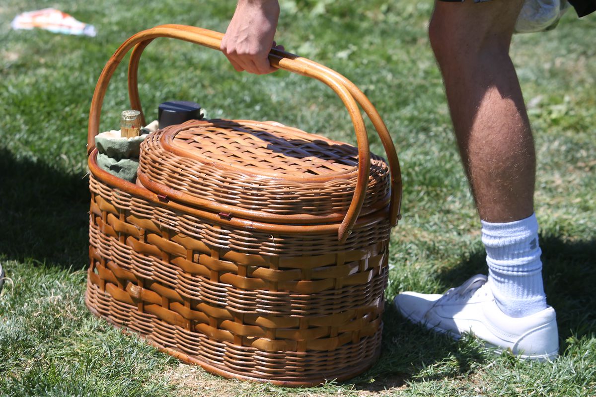 Joseph Kastelic, 17, of Redwood City, picks up a picnic basket after enjoying a picnic in Dolores Park on Wednesday, July 1, 2020 in San Francisco, Calif.