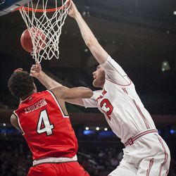 Utah Utes forward David Collette (13) misses his shot and gets his hand stuck in the net trying to gain the rebound over Western Kentucky Hilltoppers guard Josh Anderson (4) as the Runnin' Utes take on the Western Kentucky Hilltoppers in the semifinal round of the 2018 NIT in Madison Square Garden in New York City on Tuesday, March 27, 2018.