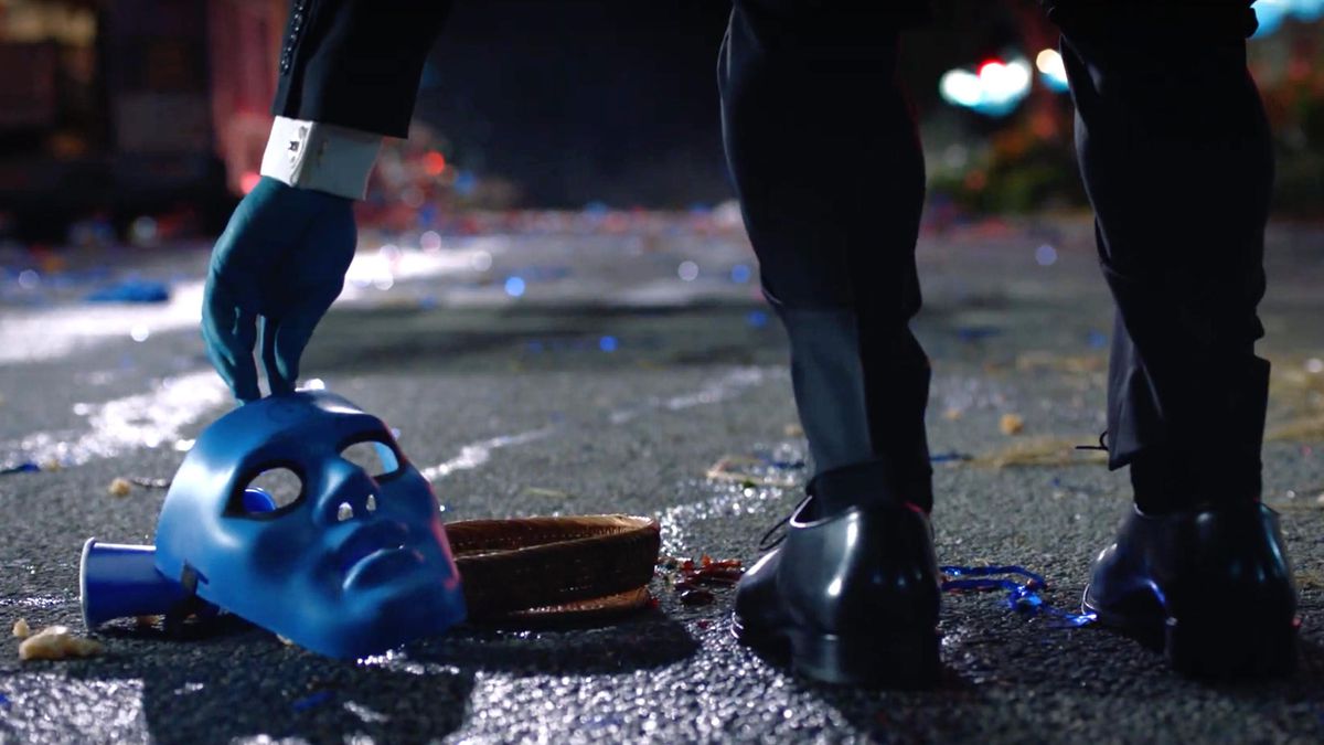 doctor manhattan picks a blue mask off the ground in hbo’s watchmen