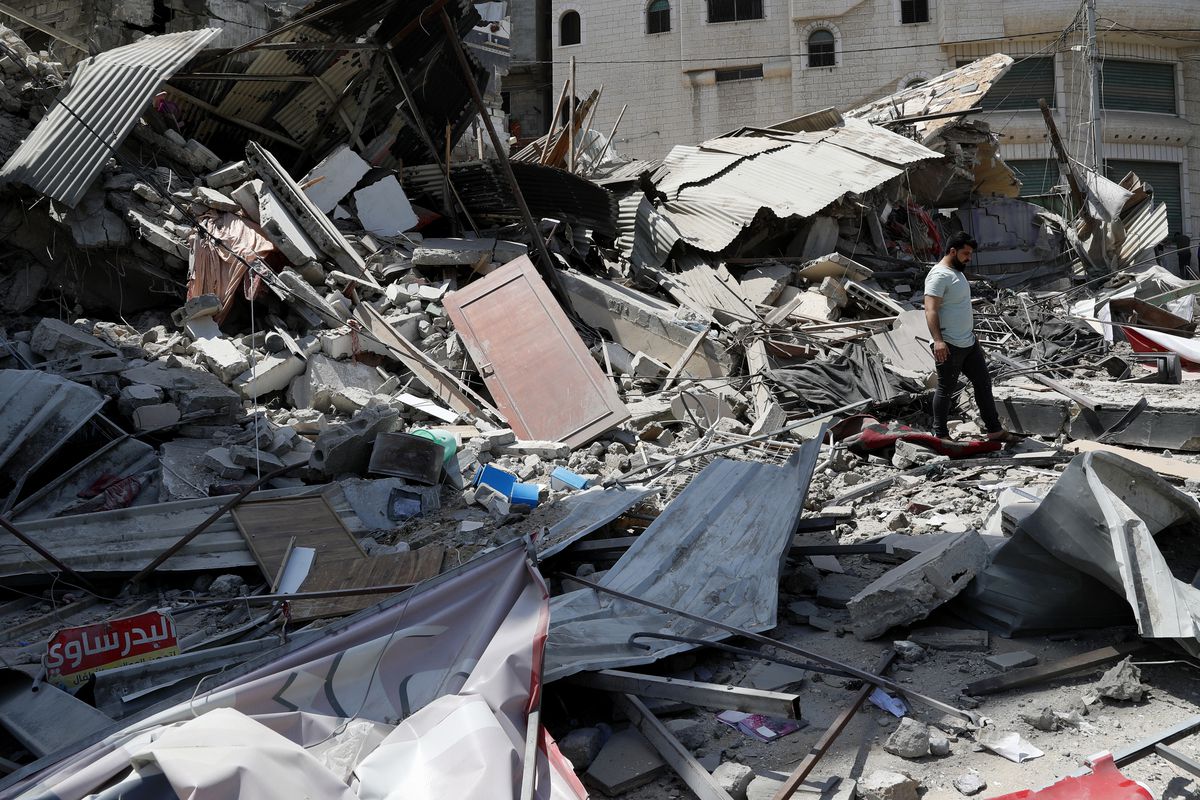 A man inspects the rubble of destroyed residential building which was hit by Israeli airstrikes, in Gaza City, Thursday, May 20, 2021. 