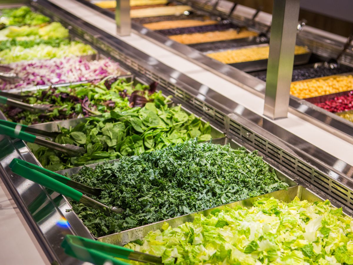 A salad bar stocked with a variety of greens.