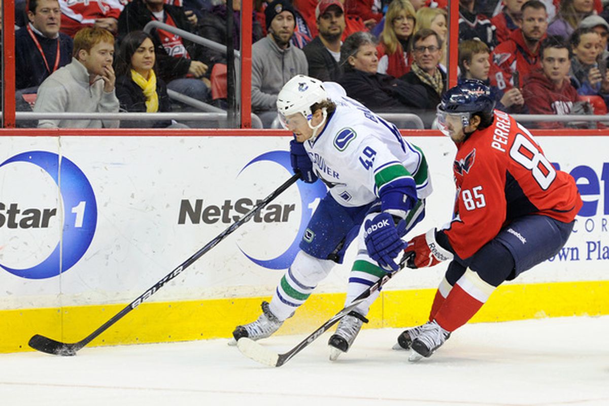 WASHINGTON - JANUARY 14:  Alexandre Bolduc #49 of the Vancouver Canucks handles the puck against Mathieu Perreault #85 of the Washington Capitals at the Verizon Center on January 14 2011 in Washington DC.  (Photo by Greg Fiume/Getty Images)