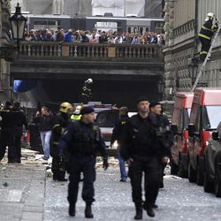 Policemen and firefighters inspect the scene of an explosion in downtown Prague, Czech Republic, Monday, April 29, 2013. Police said a powerful explosion has damaged a building in the center of the Czech capital and they believe some people are buried in the rubble. (AP Photo/Petr David Josek)