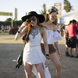 Coachella Style 101 in one photo: A great hi-lo jumpsuit/dress, fringe shorts, chunky jewelry, and a flower crown!