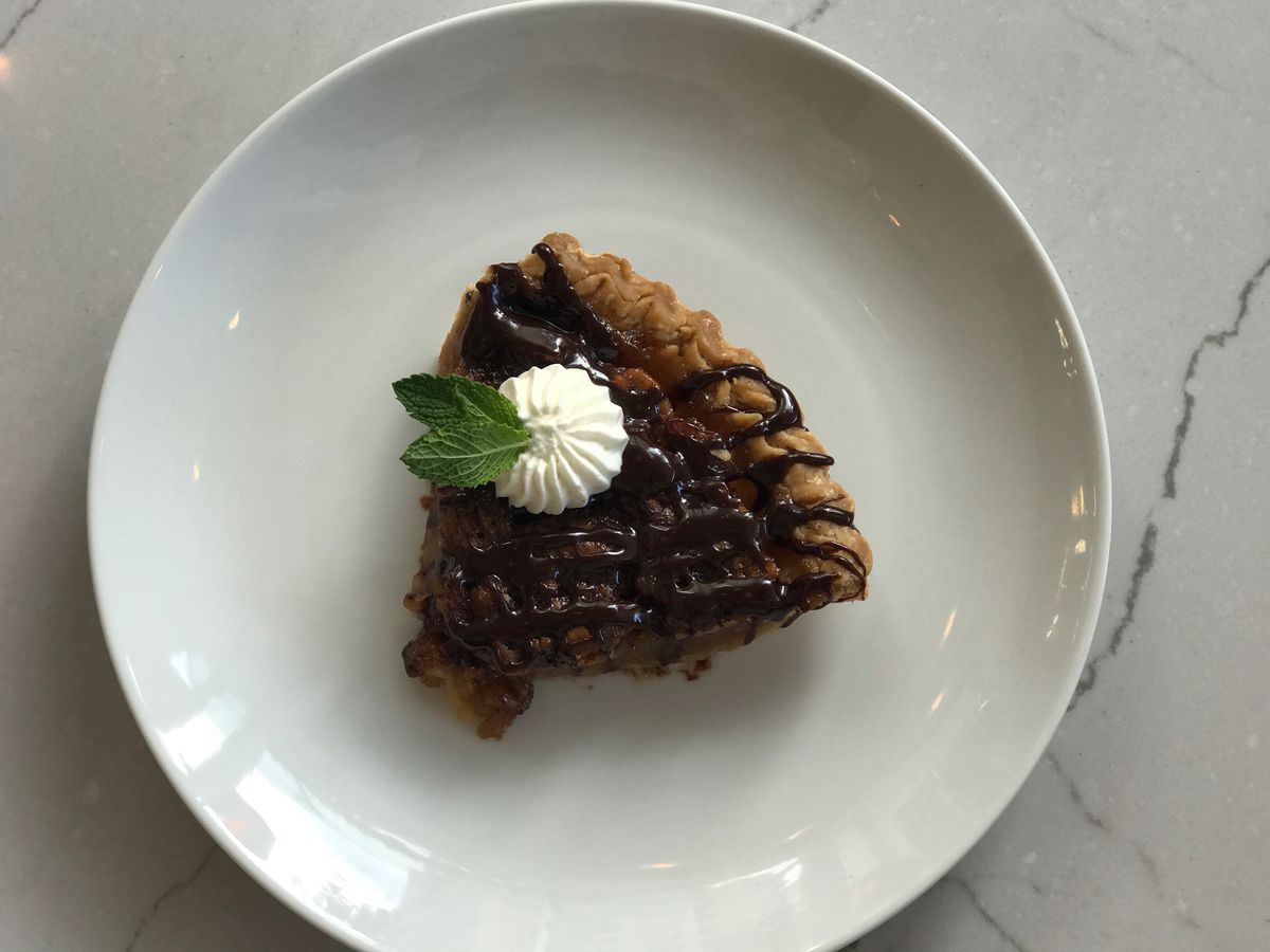 A photo of a slice of the browned butter pecan pie from Tupelo Honey on a white plate