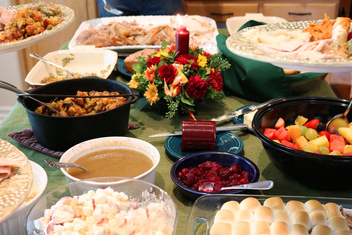 Casual Thanksgiving Feast on Table with Plates Being Filled 