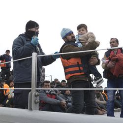 Migrants and refugees prepare to disembark from a Greek coast guard vessel after 127 people were  rescued off the shores of the Greek island of Lesbos, Tuesday, March 22, 2016. Greece detained hundreds of refugees and migrants on its islands Monday, as officials in Athens and the European Union conceded a much-heralded agreement to send thousands of asylum-seekers back to Turkey is facing delays. 