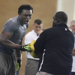 BYU's Ezekiel Ansah, left, and Oakland Raiders Coach Terrell Williams run through drills during the 2013 Pro Day at BYU in Provo on Thursday.