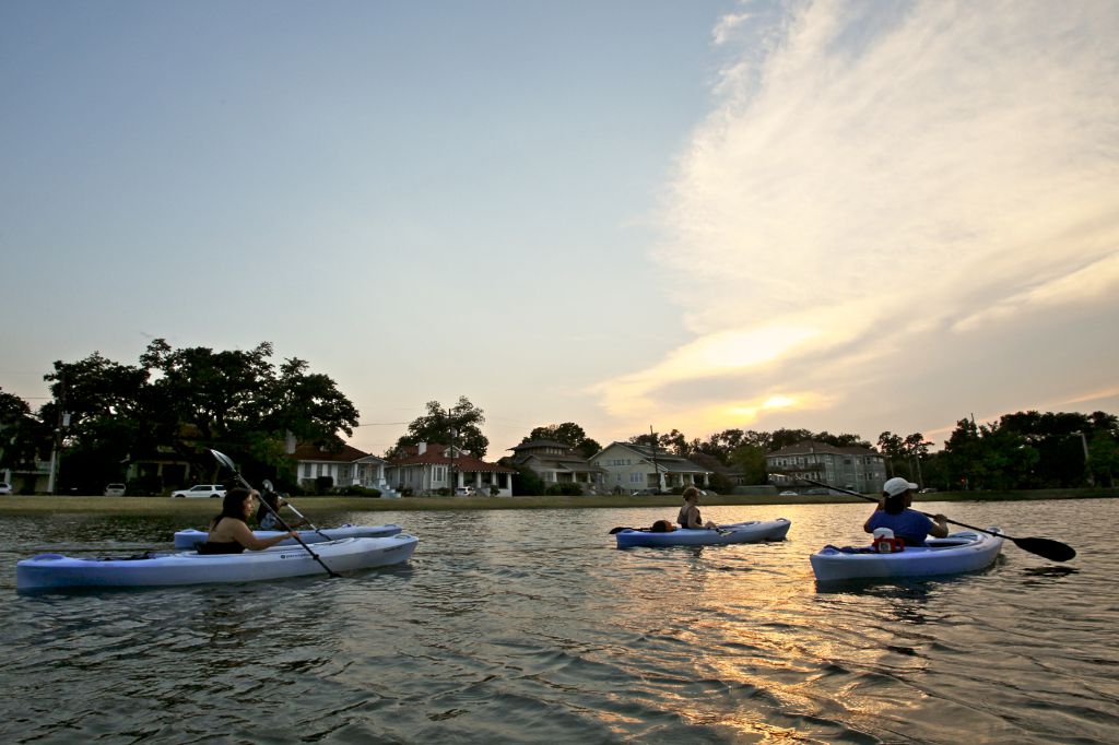 A body of water with several people in kayaks. 