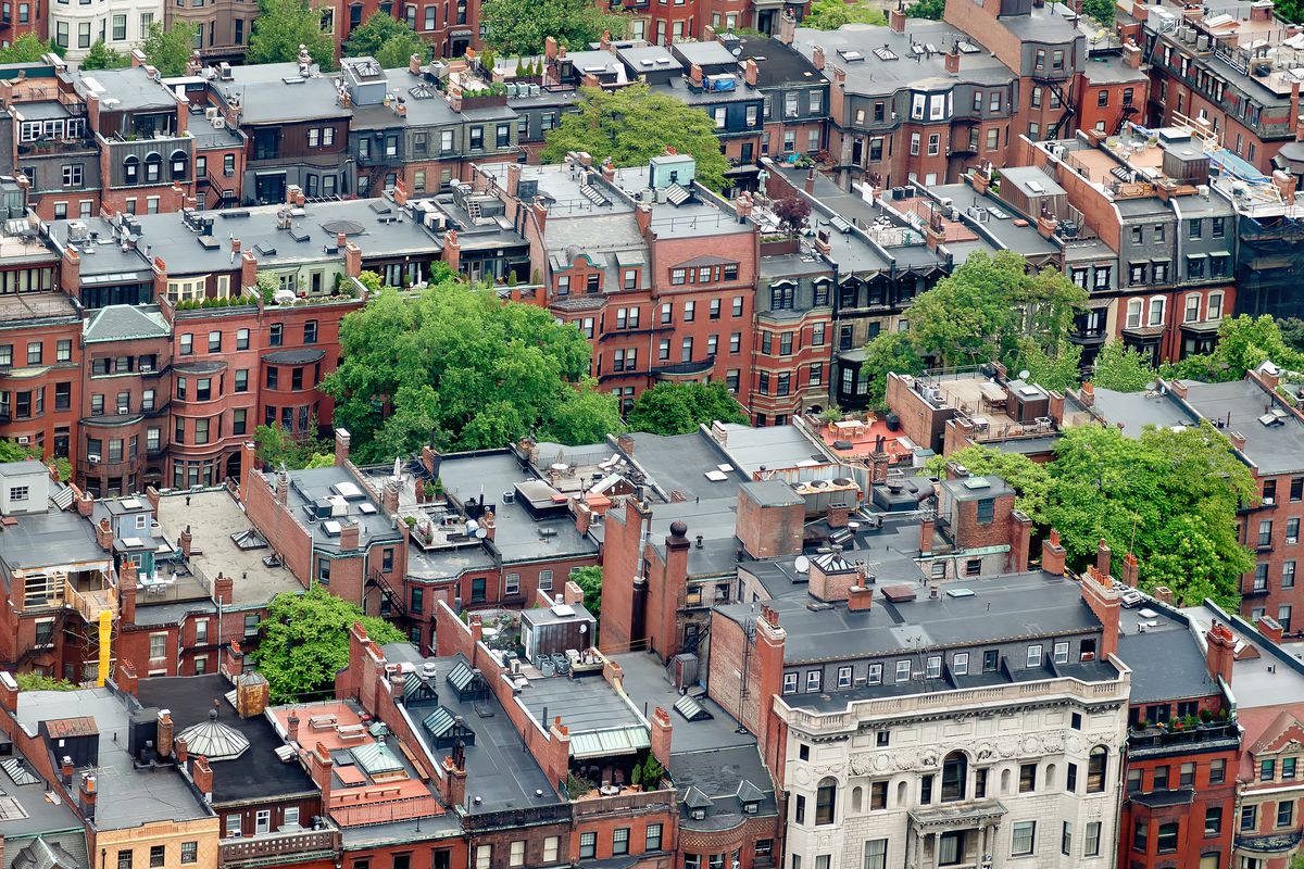 Aerial view of rows of small apartment buildings in a city.