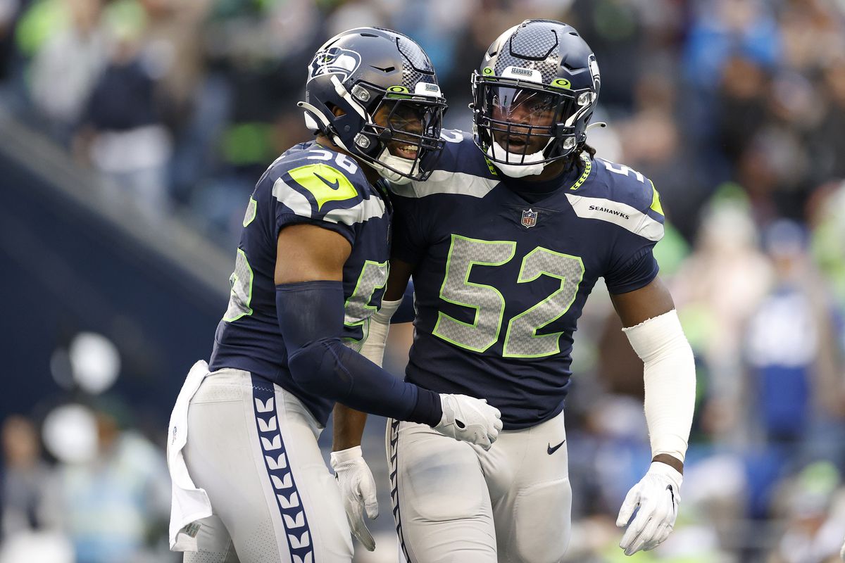 Jordyn Brooks #56 and Darrell Taylor #52 of the Seattle Seahawks celebrate a sack against the Carolina Panthers during the second quarter at Lumen Field on December 11, 2022 in Seattle, Washington.
