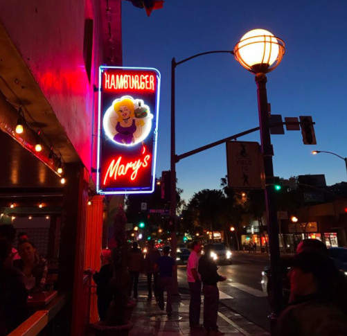 Hamburger Mary’s signage shows in front of the restaurant at dusk.