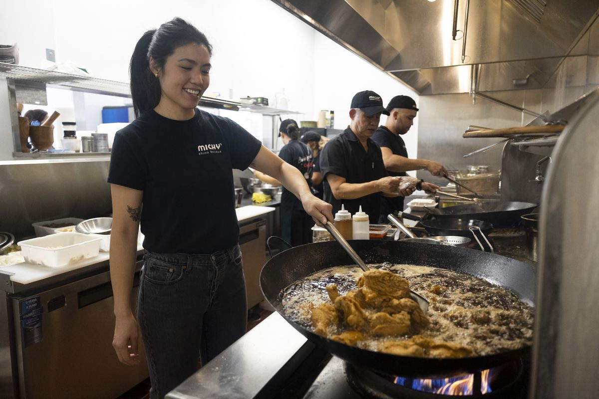 Owner Michelle Lao stirs fried chicken at Michy’s Chino Boricua on Wednesday, June 22, 2022.