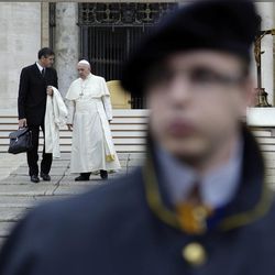 Pope Francis talks to his butler Sandro Mariotti behind a Swiss guard, as he leaves St. Peter's Square at the end of the weekly general audience at the Vatican, Wednesday, Nov. 12, 2014. 