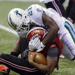 Tulane linebacker Kyle Davis (21) wraps up Louisiana-Lafayette quarterback Terrance Broadway (8) during the second half of the New Orleans Bowl NCAA college football game, Saturday, Dec. 21, 2013, in New Orleans.  