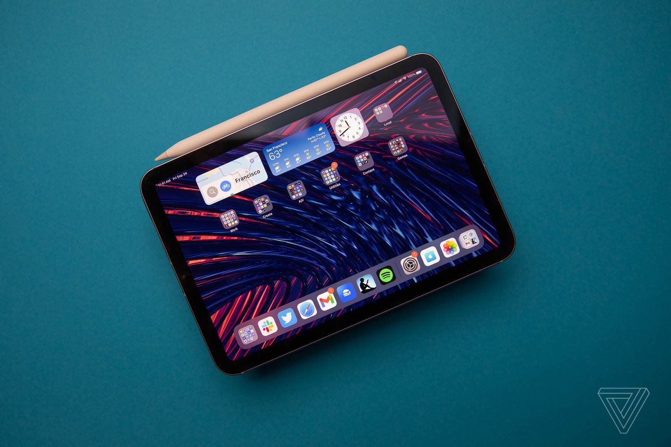 Photo of the 2021 iPad mini with attached second-generation Apple Pencil on blue background