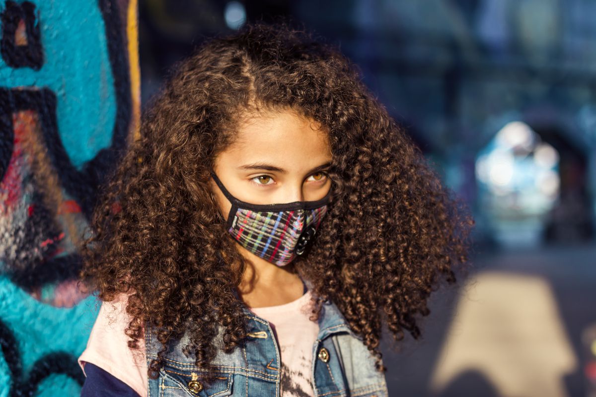 A young girl in a surgical face mask with a glitch pattern