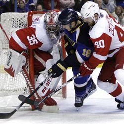 St. Louis Blues' Jay McClement, center, tries to get his stick on a loose puck as Detroit Red Wings goalie Jimmy Howard, left, and Red Wings' Henrik Zetterberg, of Sweden, defend.