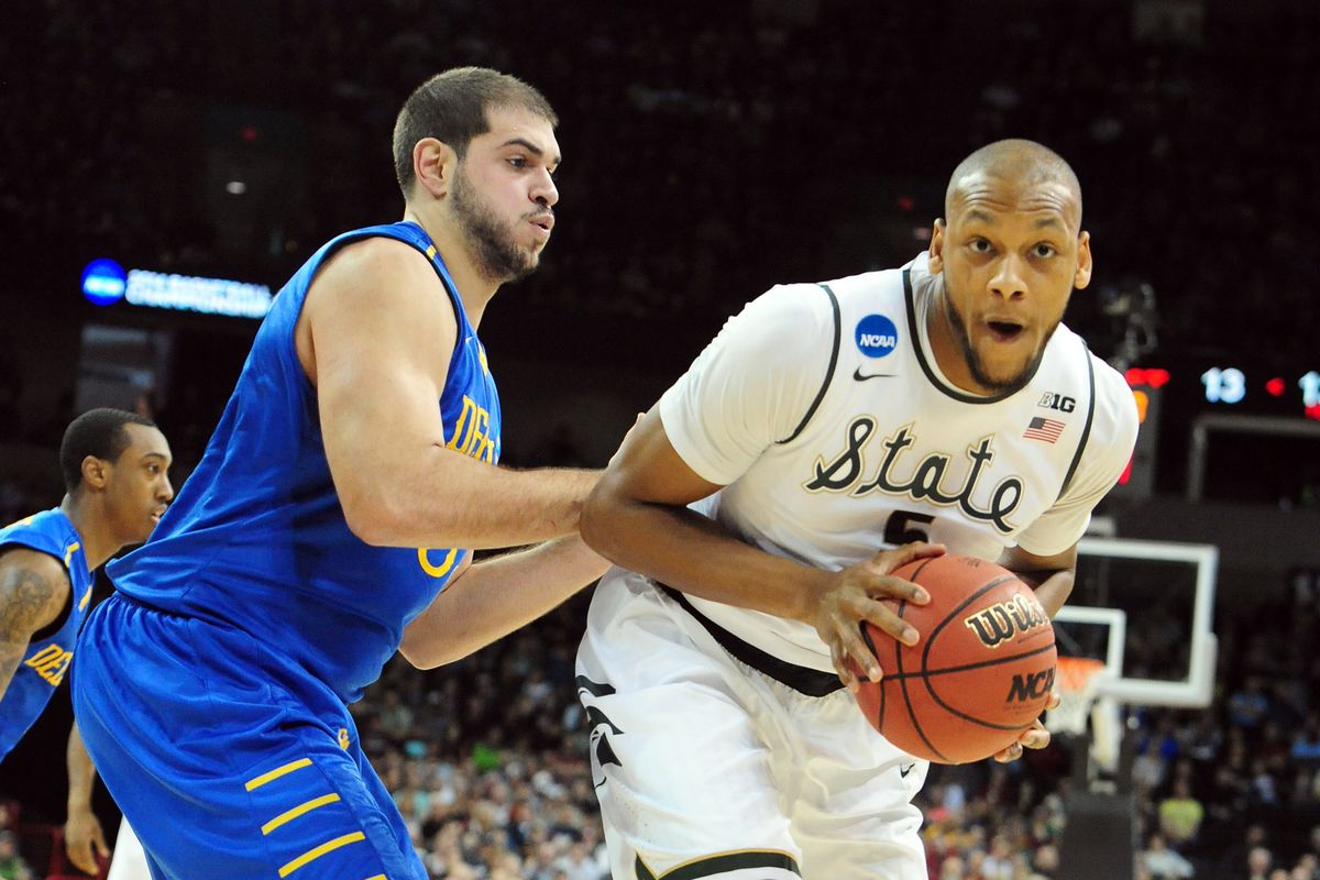 Delaware's Carl Baptiste defends Michigan State's Adriean Payne in an NCAA Tournament Second Round game in Spokane, WA.