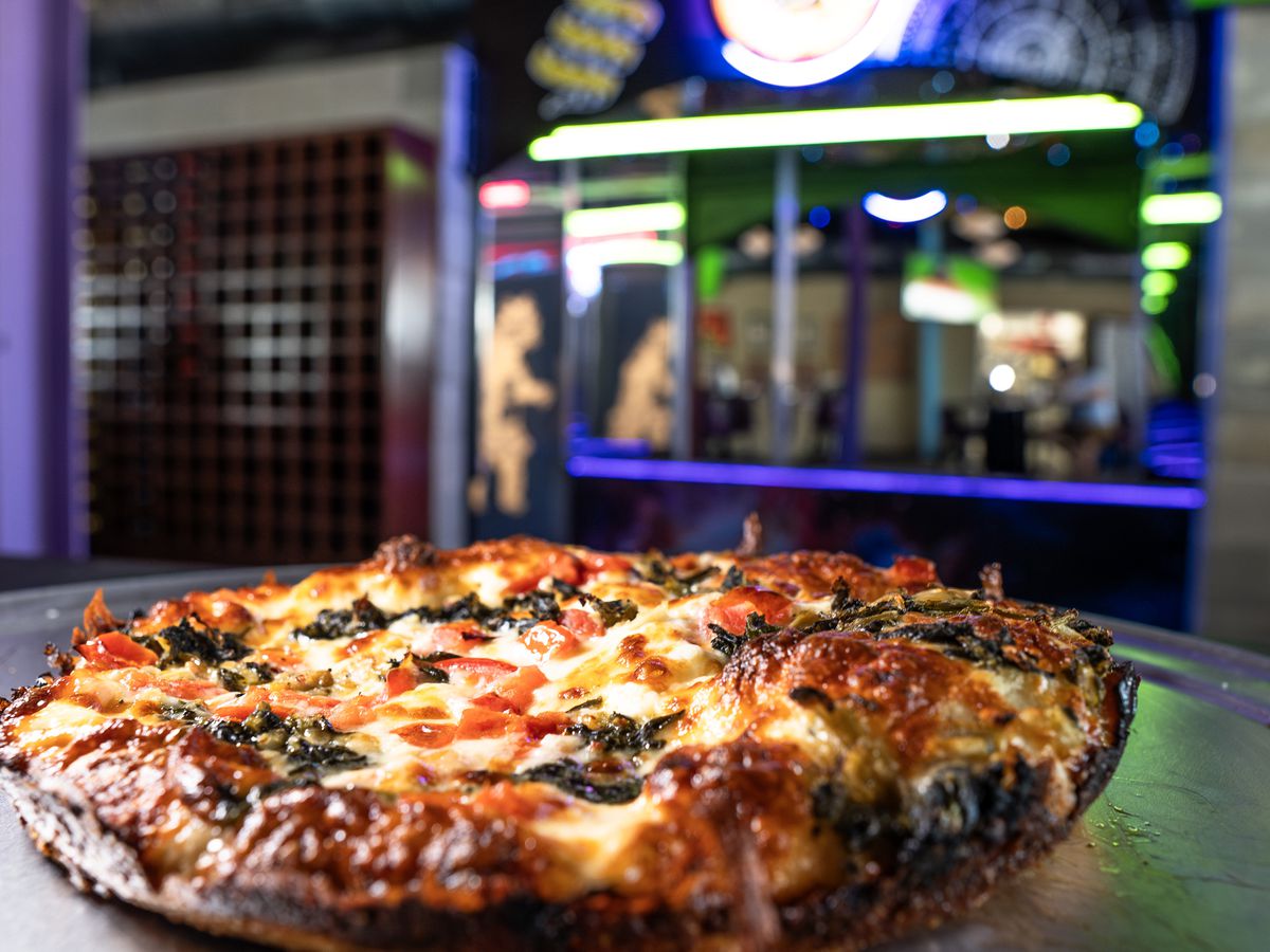 A ironclad-style pizza topped with spinach and artichoke with the backdrop of Betelgeuse Betelgeuse’s entrance.