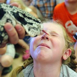 Cambrie Nelson closes her eyes as she is licked by a black and white Argentine tegu as Shane Richins of Scales and Tails Utah gives a show Wednesday, June 5, 2013, during Heber Unplugged at the Wasatch County Library.