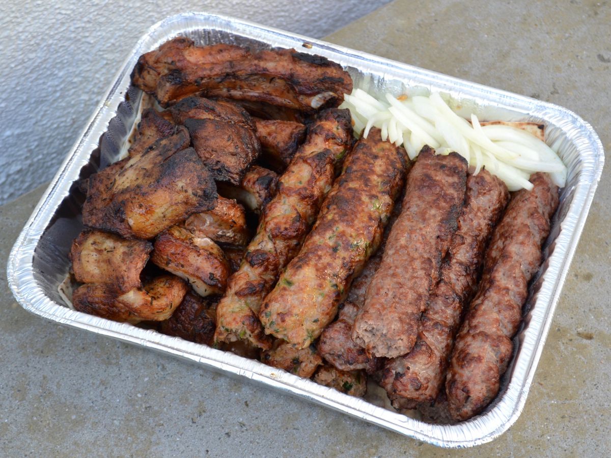 Kebab plate with lule and even herb-flecked pork at Dvin Meat Market in Glendale in an aluminum tray with white onions sliced.