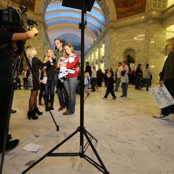 Enoch Foster speaks with media members with his wives Catrina Foster and Lillian Swapp-Foster and son Adonijah Foster as polygamy advocates voice their support of HB281 at a protest inside the Capitol rotunda Monday, March 7, 2016.
