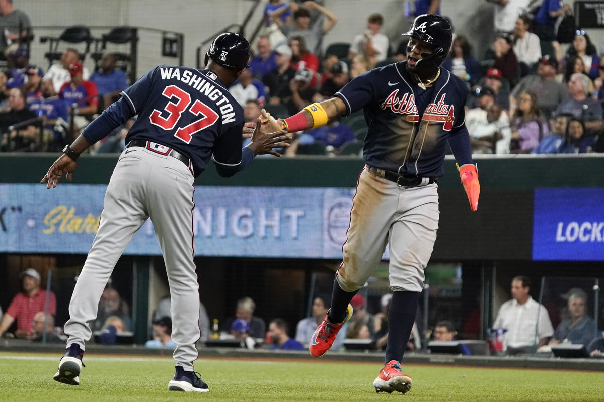 Atlanta Braves right fielder Ronald Acuna Jr. celebrates with third base coach Ron Washington after scoring against the Texas Rangers during the eighth inning at Globe Life Field.