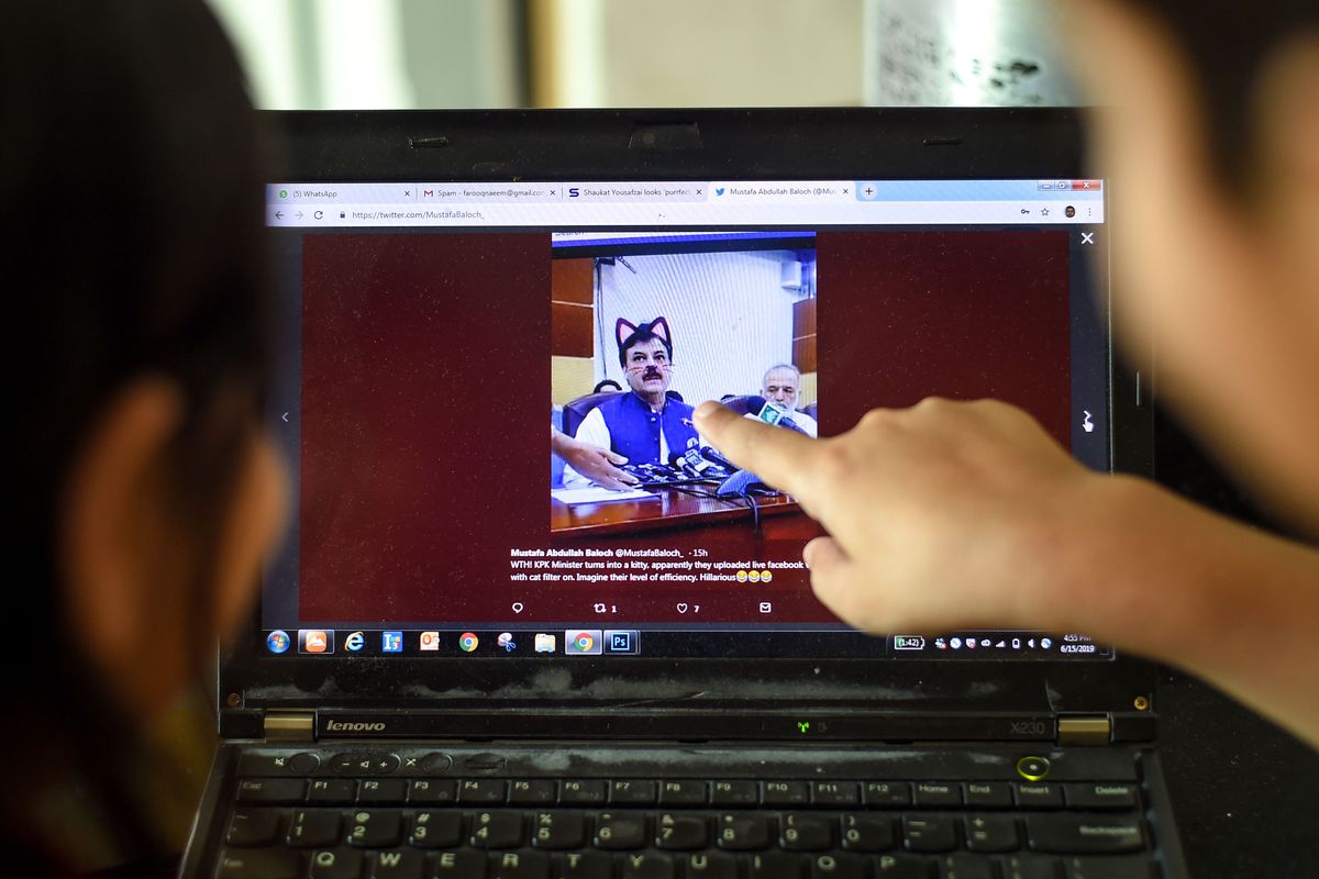 Pakistani children point at a computer screen showing a screen grab of a press conference by Shaukat Yousafzai and streamed live on Facebook, in Islamabad on June 15, 2019.