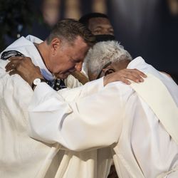Father Michael Pfleger hugs and prays with a member of the church as he celebrates Mass for the first time since January after he was reinstated as senior pastor of the Faith Community of Saint Sabina in Auburn Gresham, Sunday, June 6, 2021. The Archdiocese of Chicago cleared Pfleger to return to the South Side church after an internal probe into decades-old allegations of sexual abuse against minors.