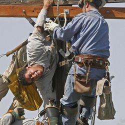 Fatu Matagi, 28, hangs on while he is rescued on Aug. 26, 2008. Matagi was was one of two contractors caught in an electrical accident in which the other man was killed in Holladay.