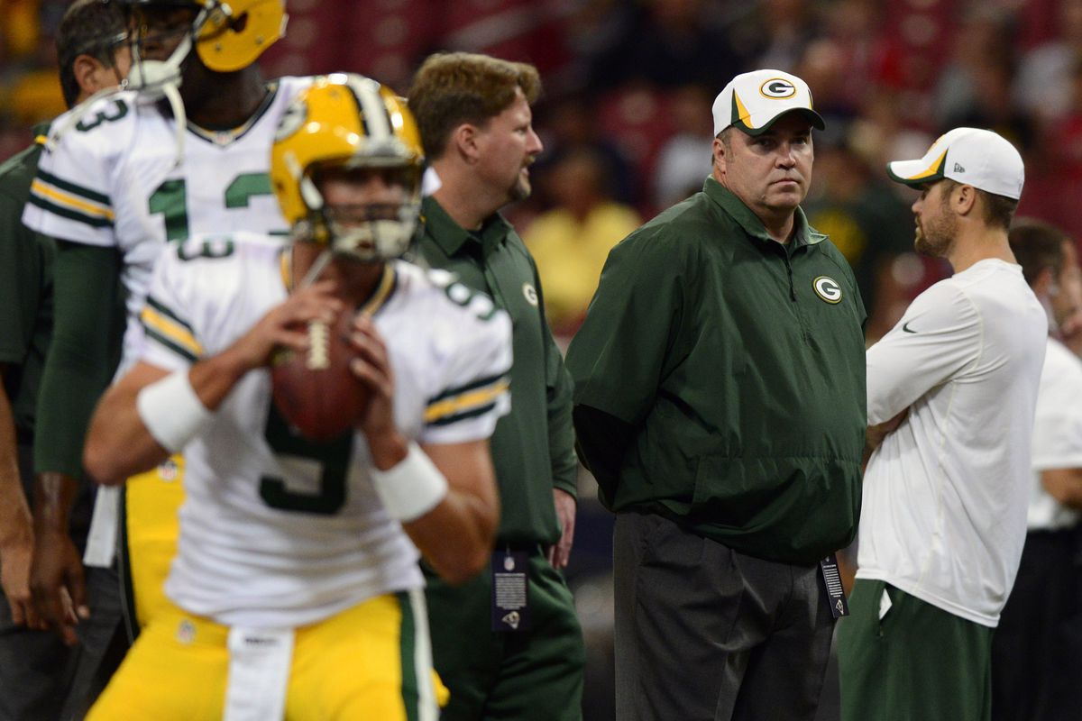 Coach McCarthy looks on as B.J. Coleman (9) and Vince Young (13) warm up before the Packers preseason game against the Rams on August 17th