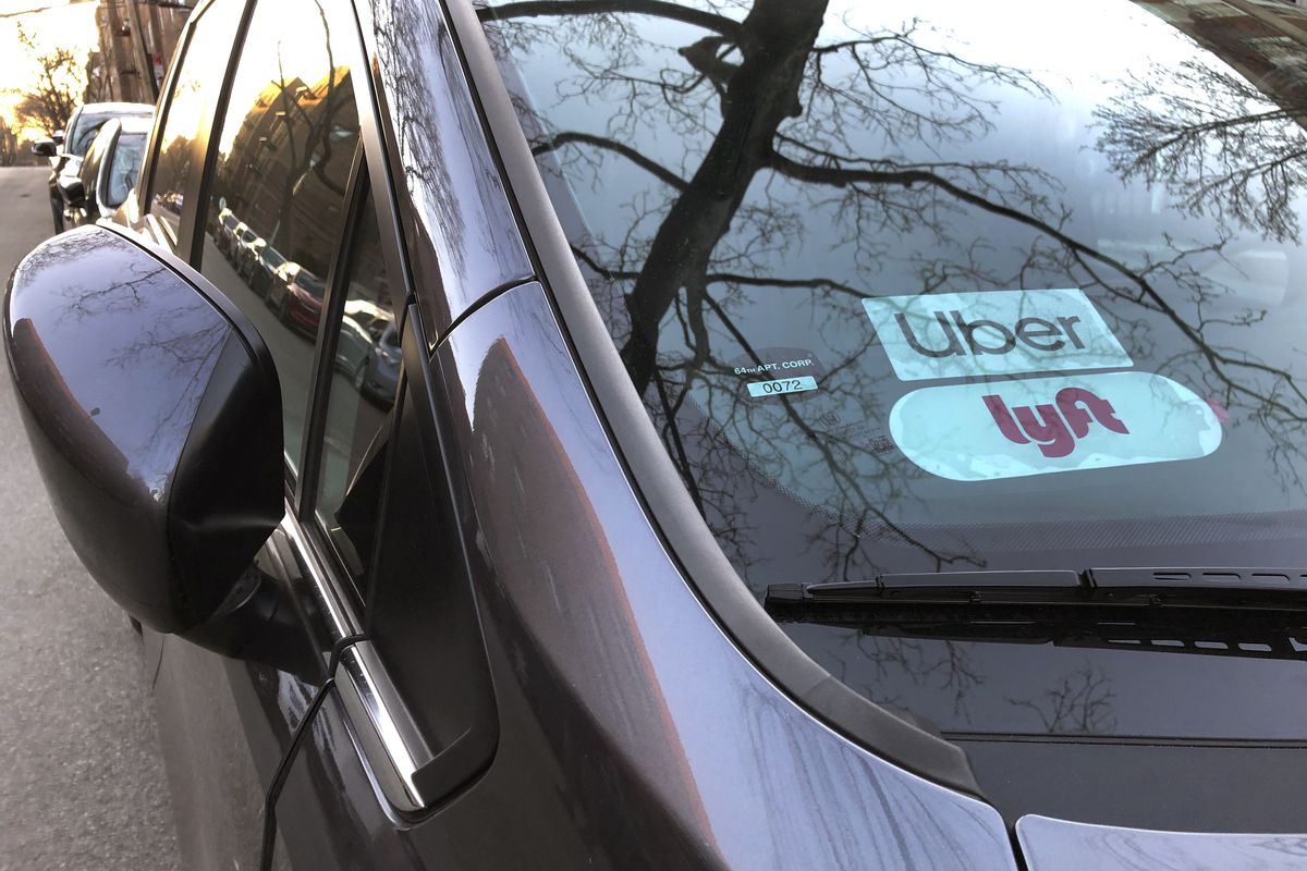 Uber and Lyft sign in windshield of car, Queens, New York