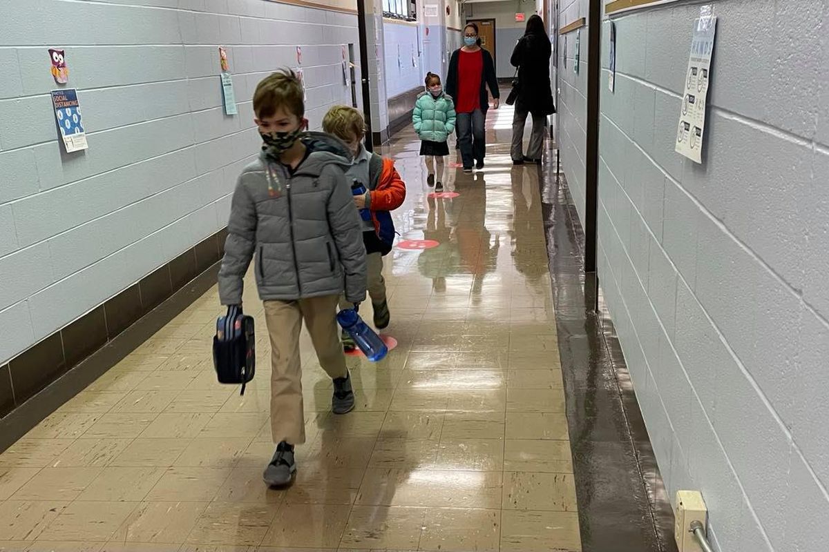 Wearing masks, kindergarten students walk back to their classroom after taking a restroom break at Chester Arthur Elementary School in South Philadelphia.