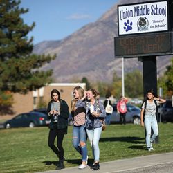 People leave Union Middle School in Sandy following a shooting involving two juveniles outside the school on Tuesday, Oct. 25, 2016.