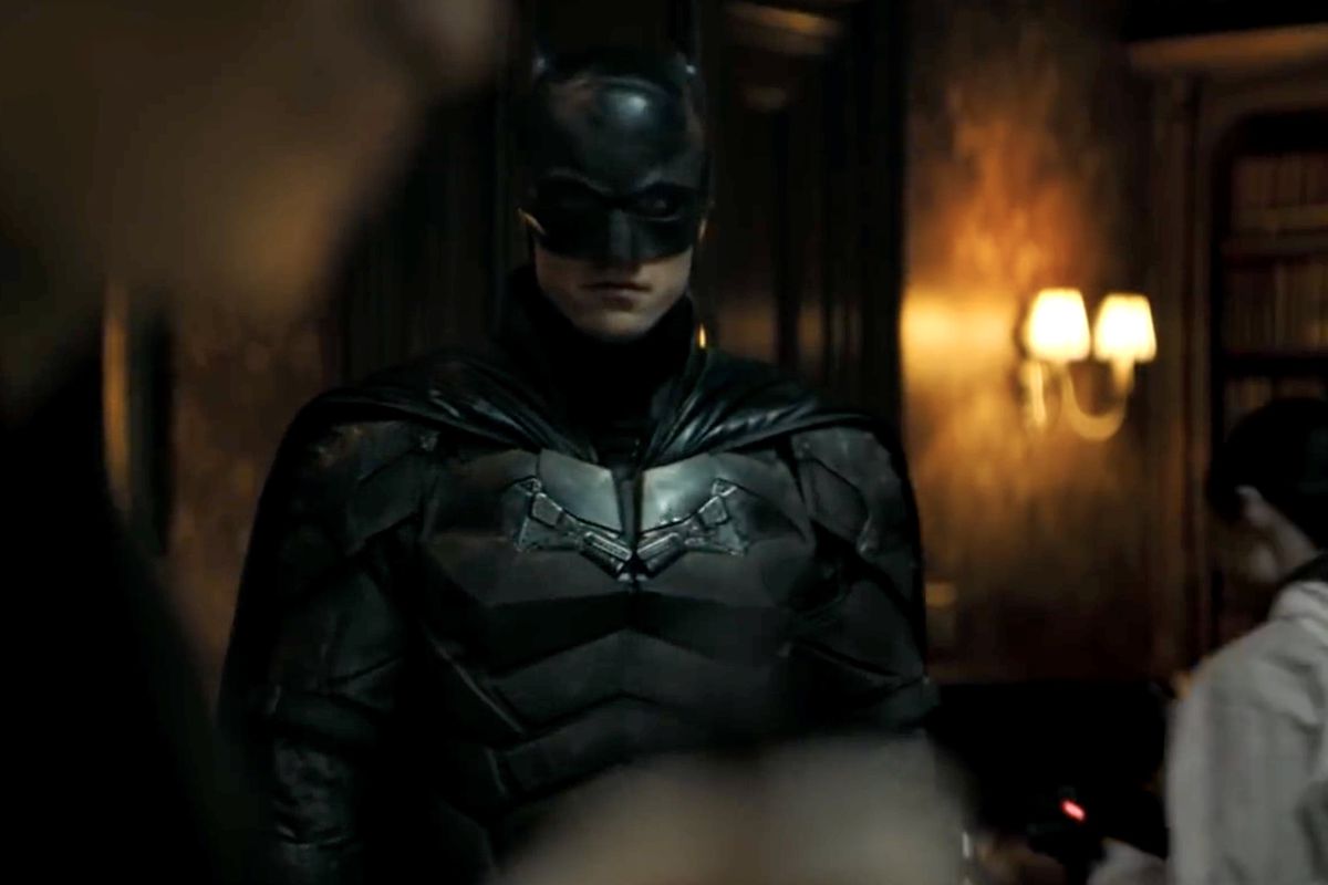 Robert Pattinson as The Batman standing in a mansion surveying a murder in the DC Fandome 2020 trailer