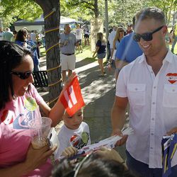 Chad McMullin hands out equality flags during a rally celebrating the Supreme Court's decision to legalize same-sex marriage at City Creek park in Salt Lake City on Friday, June 26, 2015.