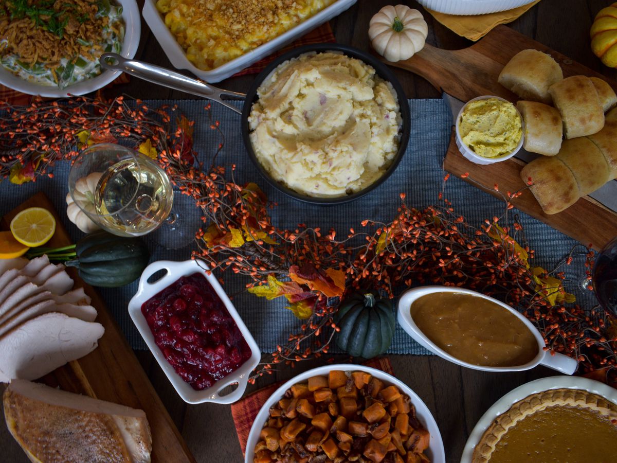 An array of Thanksgiving dishes on a dark background. 