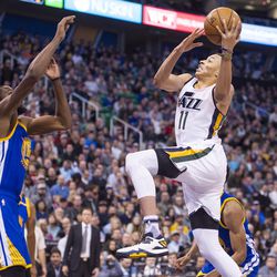 Utah guard Dante Exum (11) goes up against Golden State forward Kevin Durant (35) during the first half of an NBA basketball game in Salt Lake City on Thursday, Dec. 8, 2016.