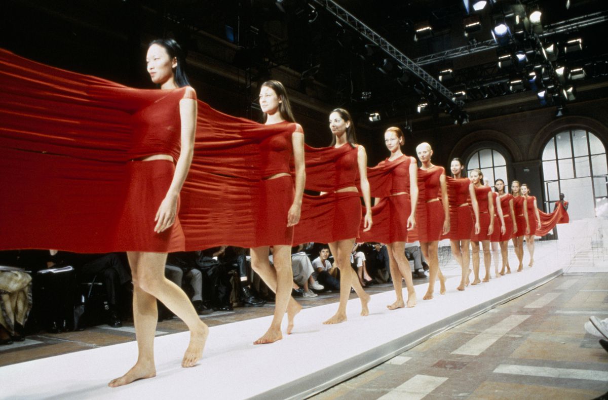 Nearly a dozen models wear a single, unified garment, which stretches from person to person down the runway.