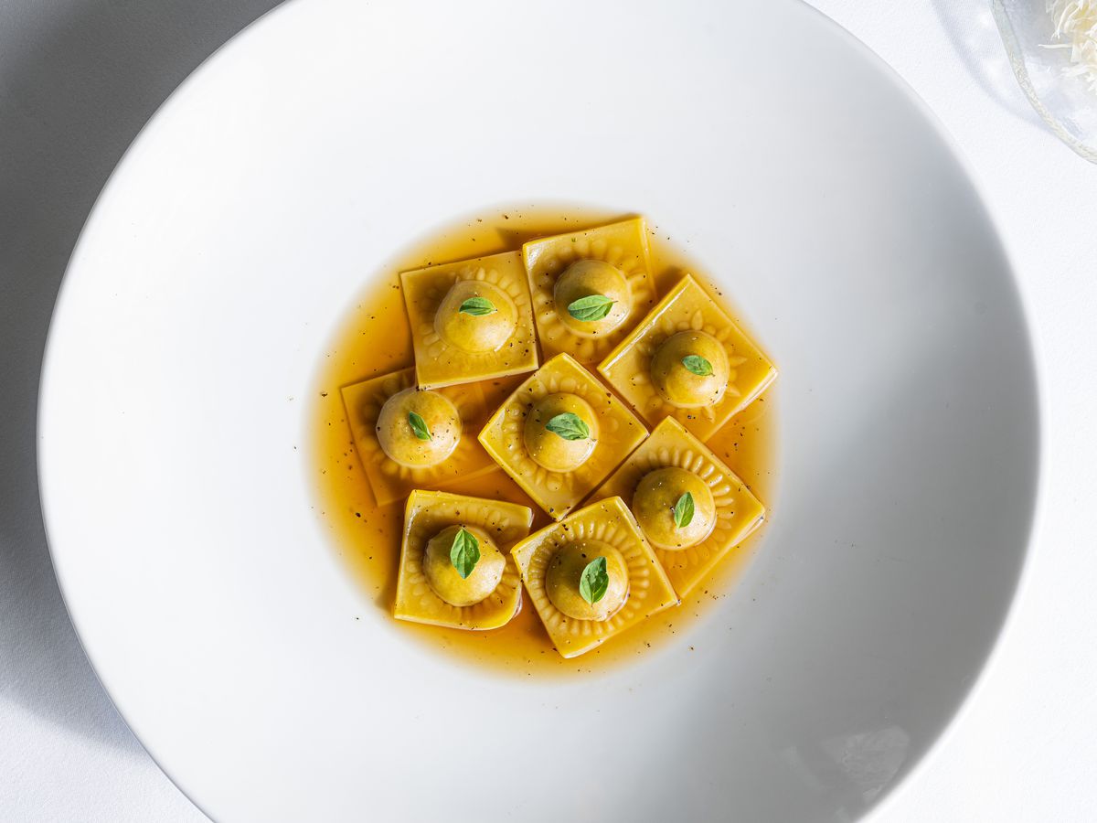 A bowl of Pastore’s chicken sausage ravioli topped with microgreens.