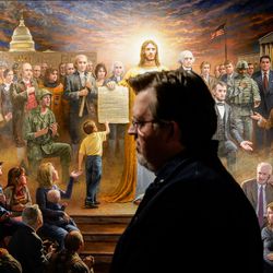 Artist Jon McNaughton stands in front of one of his paintings at his studio in Utah County on Monday, Nov. 22, 2021.
