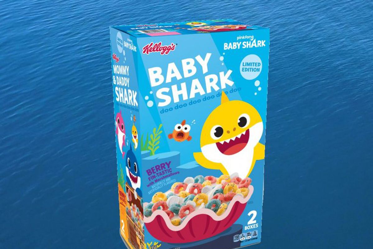 a blue ocean background with a blue box of Baby Shark cereal with a yellow shark on the front and a pink clam shell bowl of fruit loop and shark-shaped marshmallow cereal.
