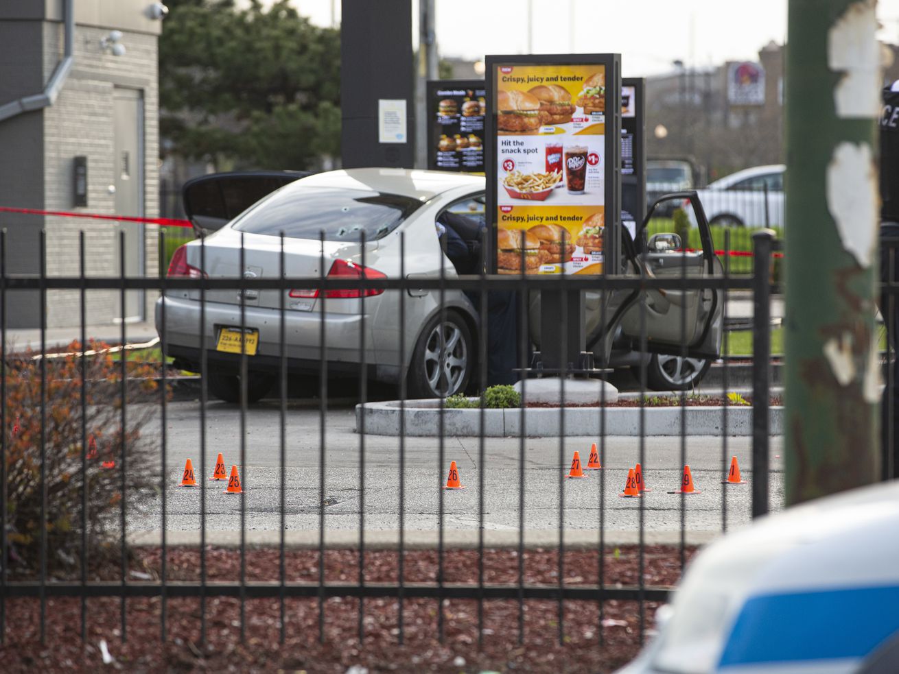 Shell casings litter the scene at a McDonald’s parking lot Sunday afternoon where a 7-year-old girl was shot and killed and her father was seriously wounded as they waited in a drive-thru.