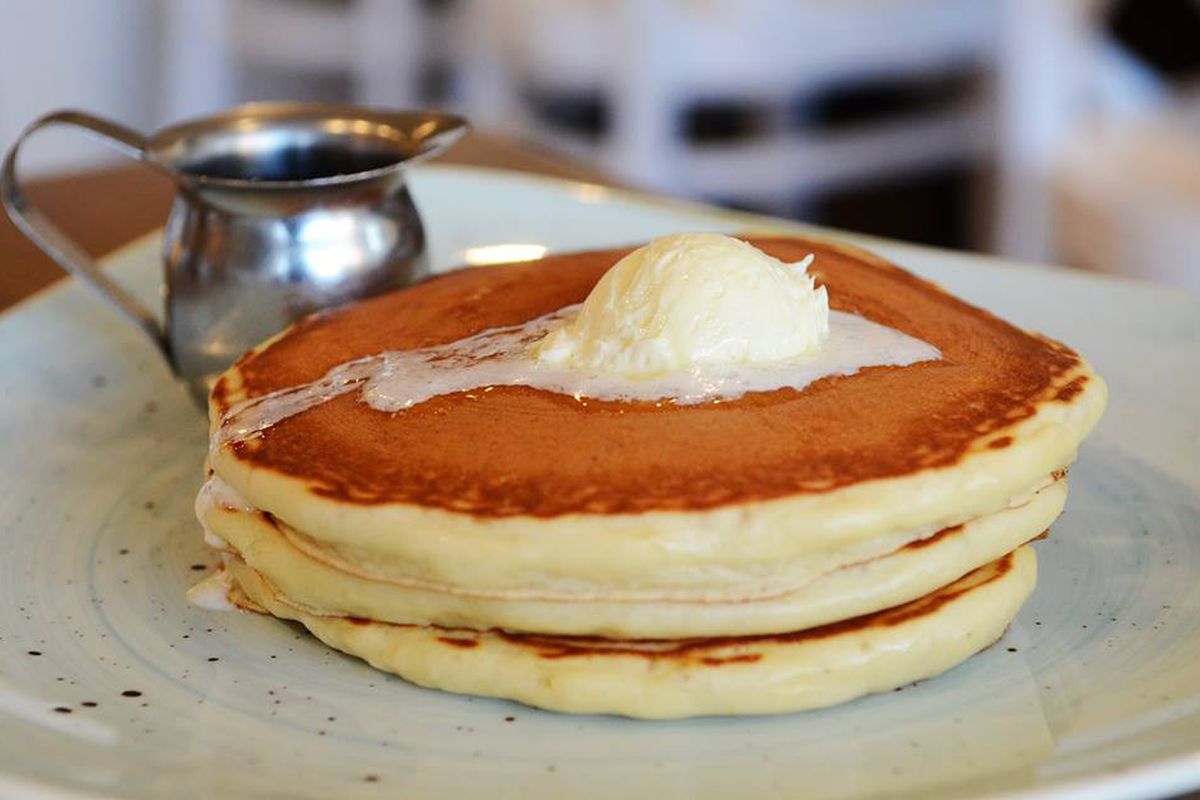 A stack of buttermilk pancakes on a white plate. 