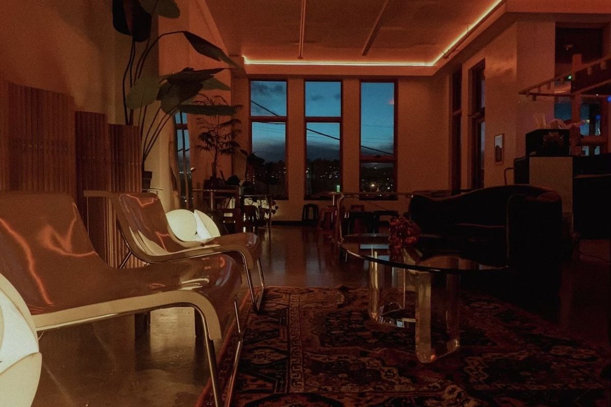 A lounge space with seating cast in orange lighting.