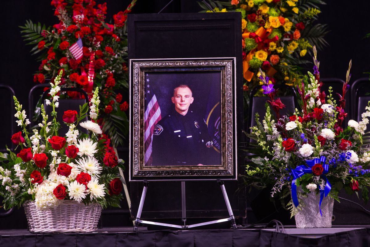 A photo of West Valley police officer Cody Brotherson sits at the podium during funeral services at the Maverik Center in West Valley City on Monday, Nov. 14, 2016.