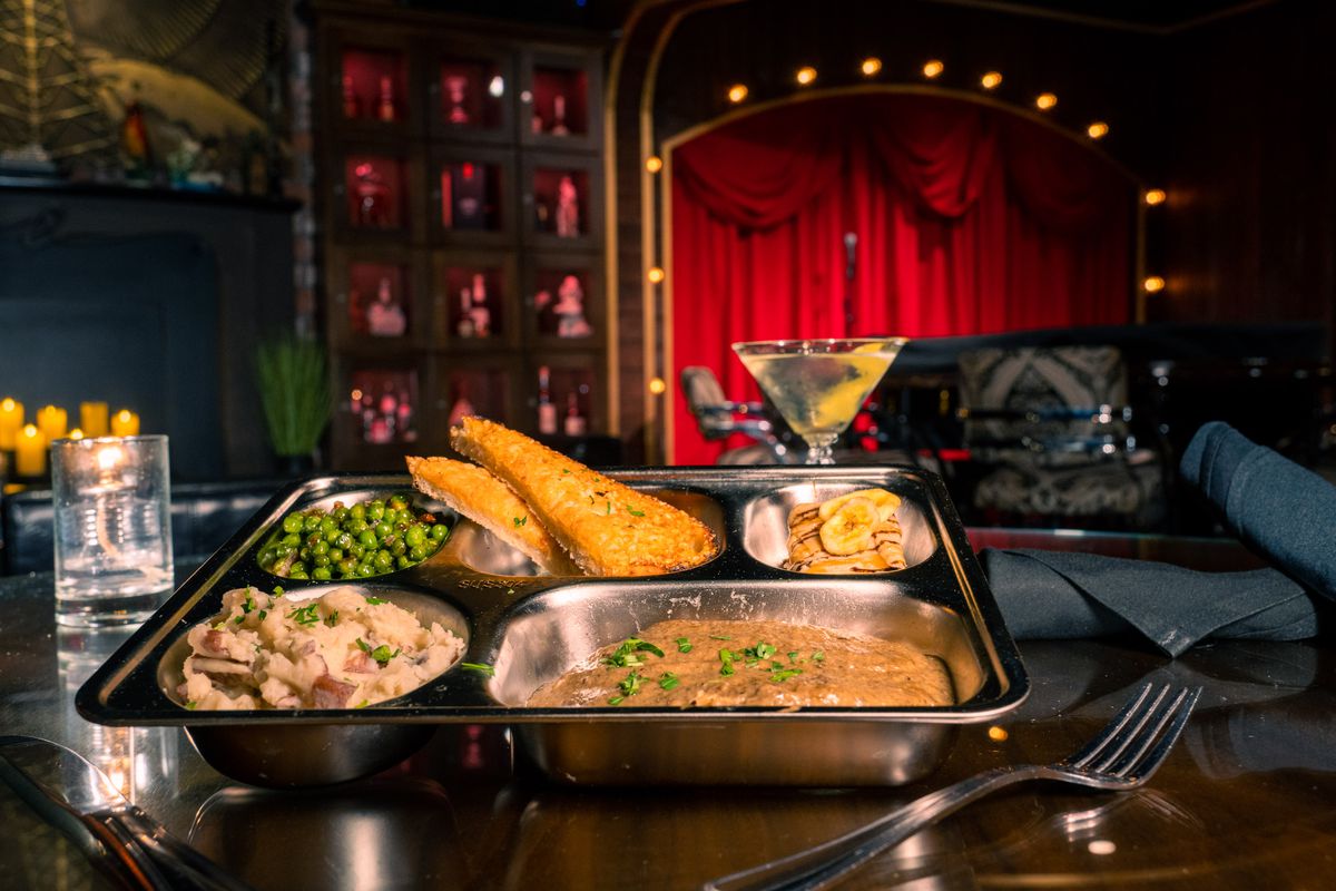 A TV dinner in a silver tray.