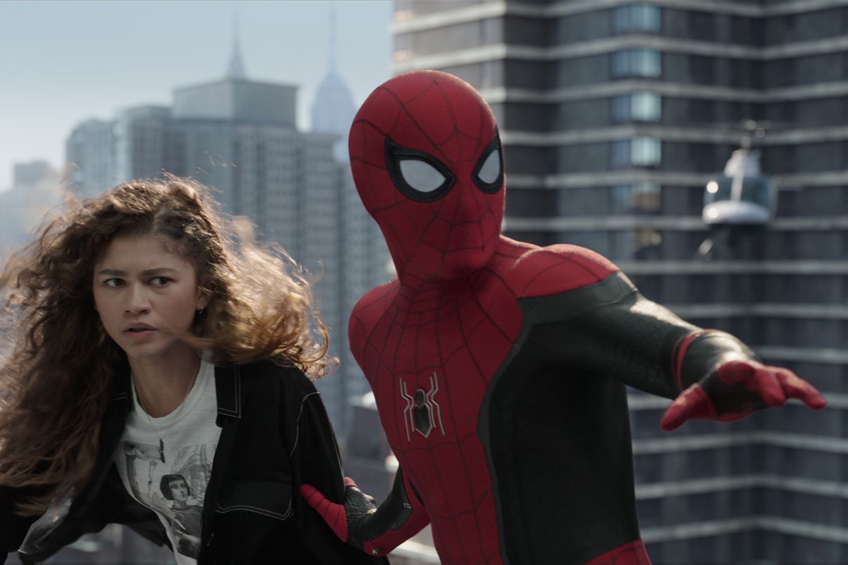 Spider-Man (Tom Holland) and Mary Jane (Zendaya) stand on top of a building after swinging in Spider-Man: No Way Home